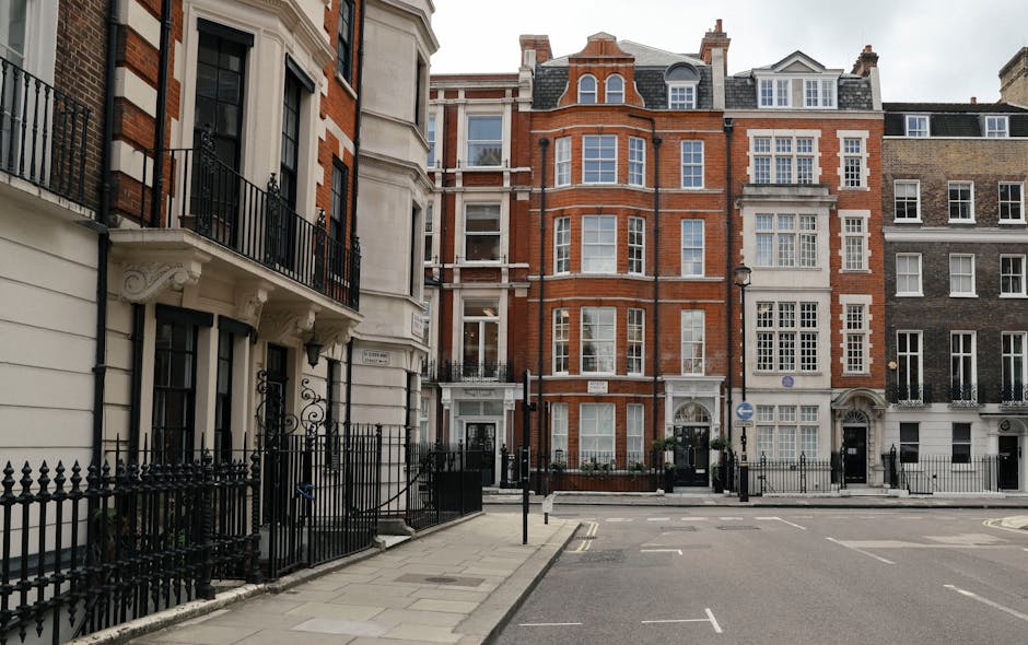 Photograph of a multi-storey Victorian residential building constructed with red brick and stone detailing, located on a narrow street in Belgravia. The building features large sash windows with white